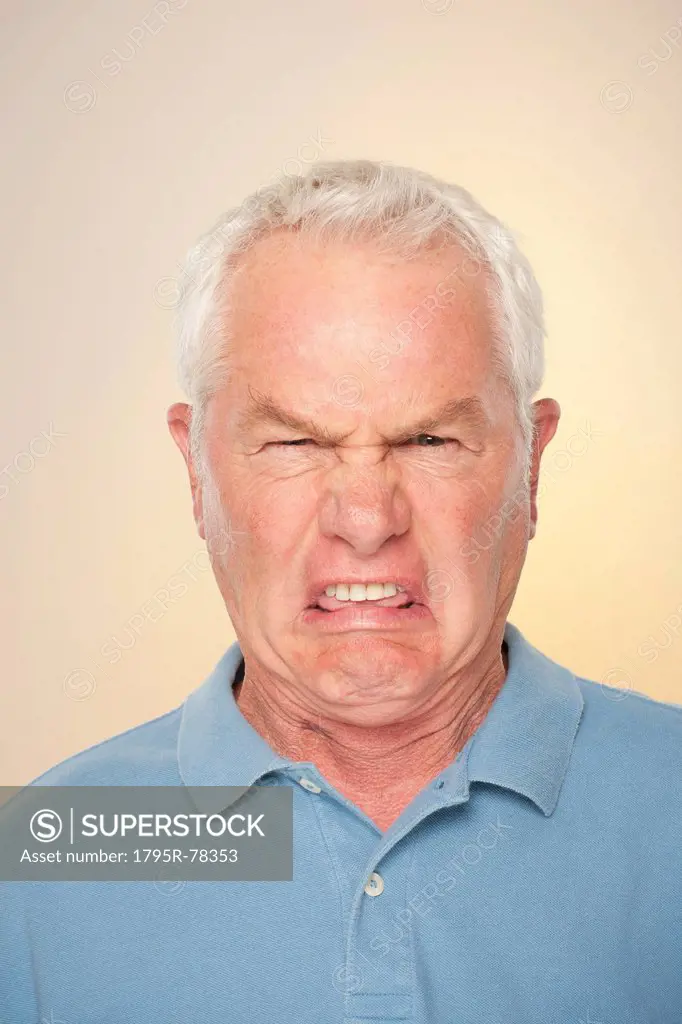 Portrait of senior man with disgusted face expression