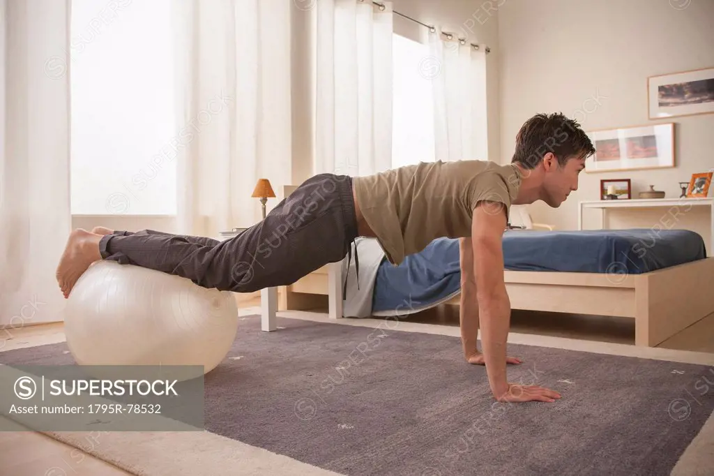 Man doing yoga using fitness ball