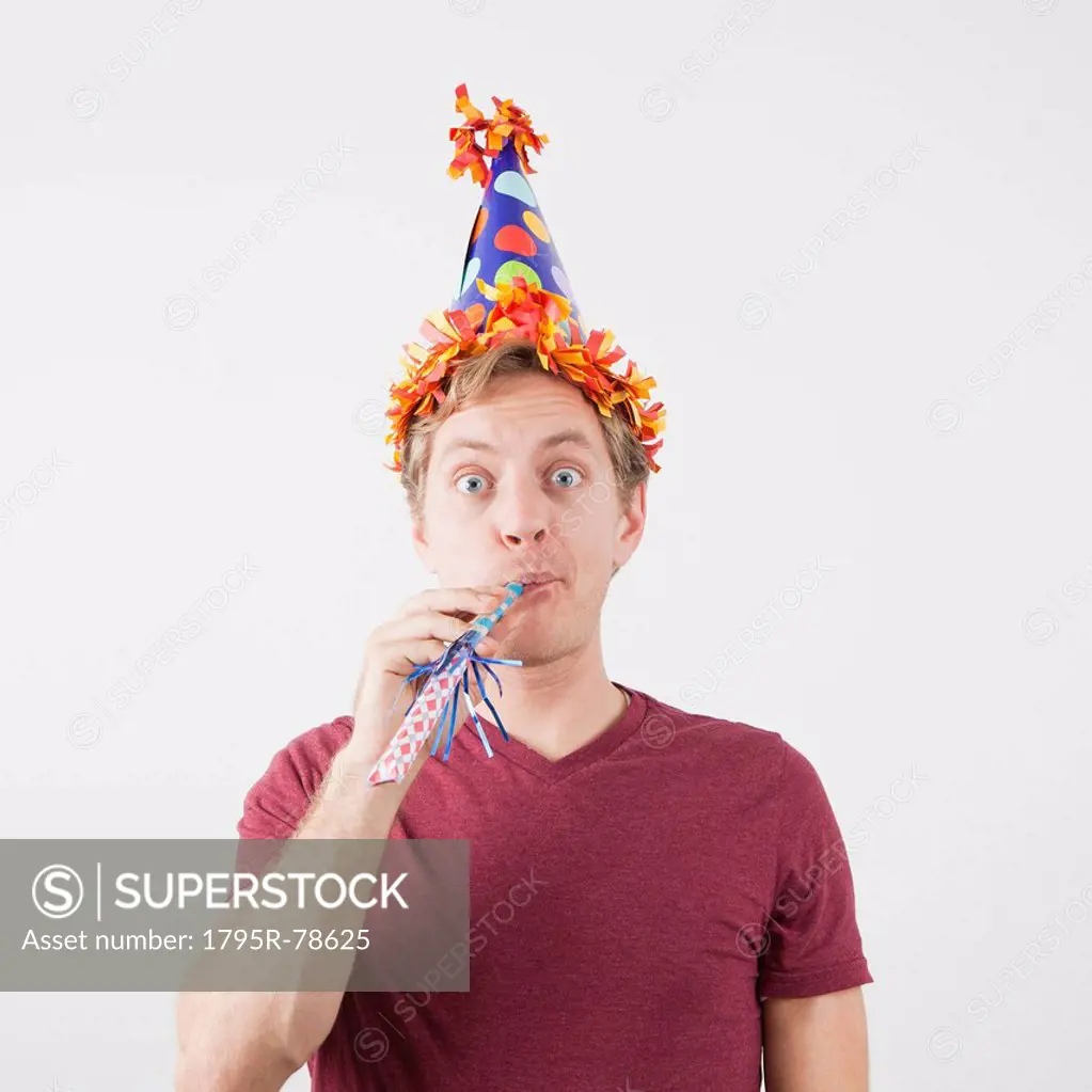 Man with party hat and party horn blower