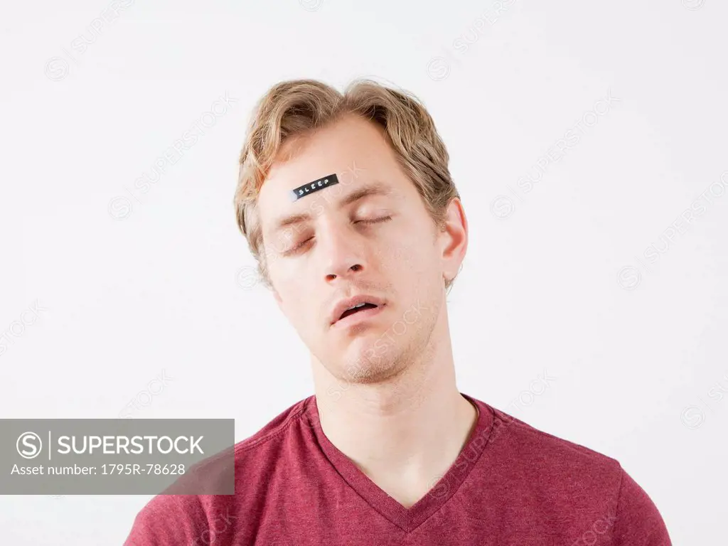 Sleeping man with sticker on his forehead