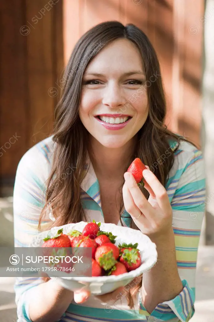 Portrait of mid adult woman eating strawberries