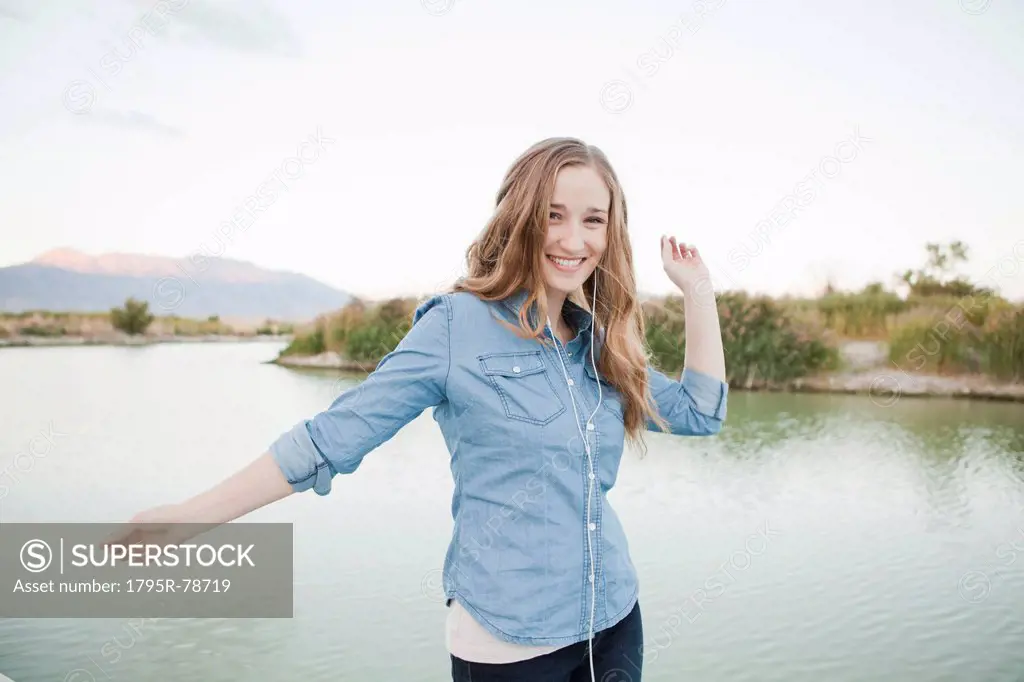 Portrait of young woman dancing player by lake