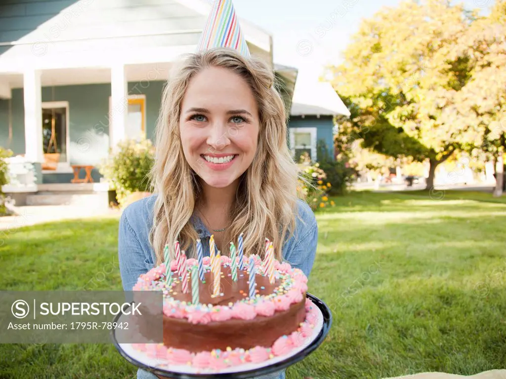 Portrait of young woman holding birthday cake