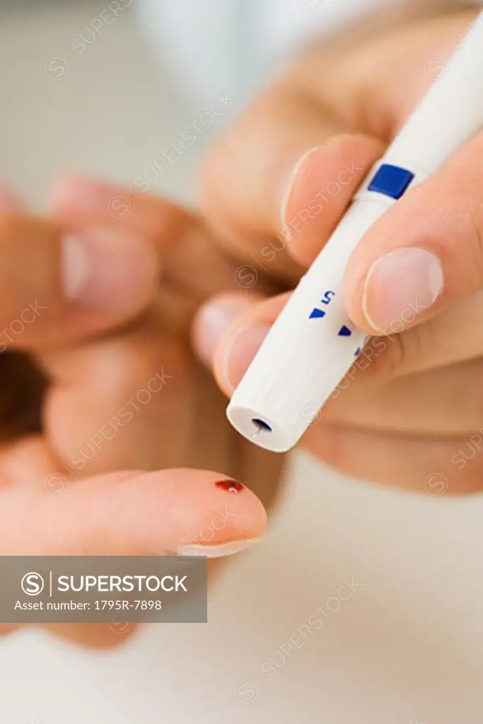Person using blood sugar monitor on finger