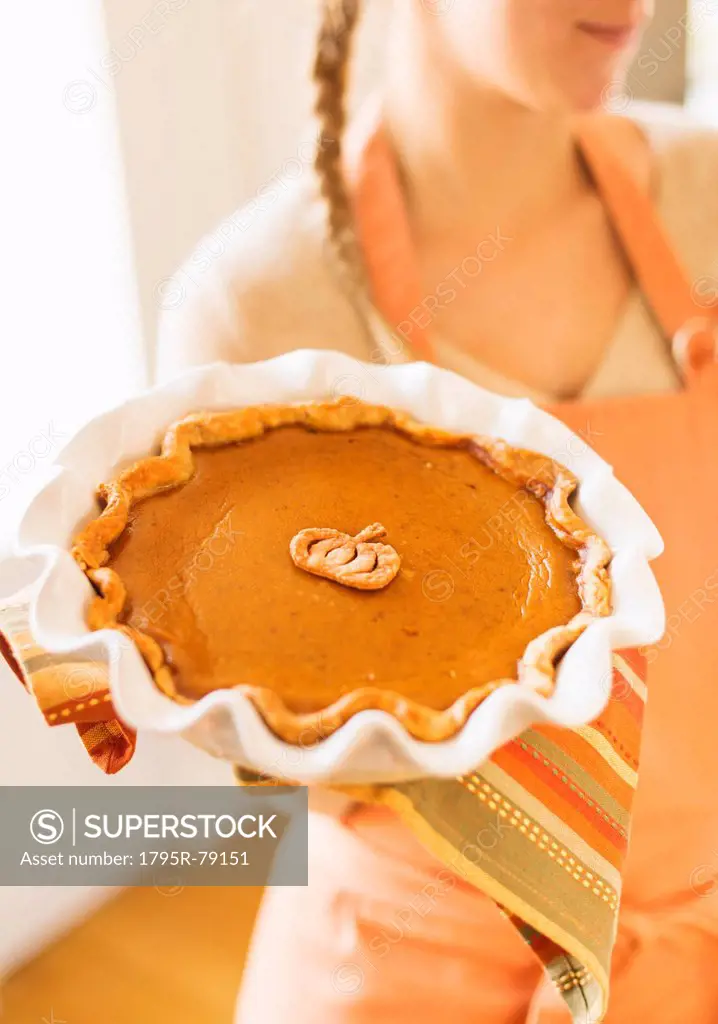 Woman holding pumpkin pie
