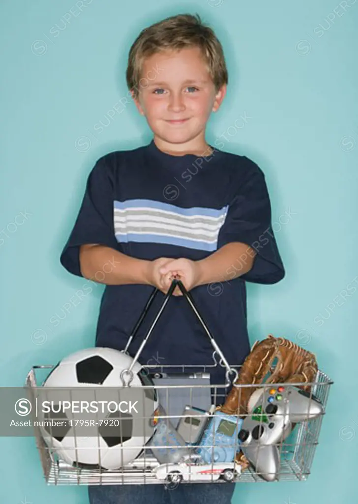 Boy holding shopping basket with toys