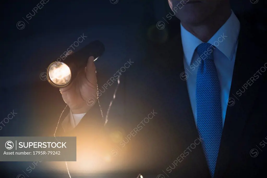 Businessman holding flashlight