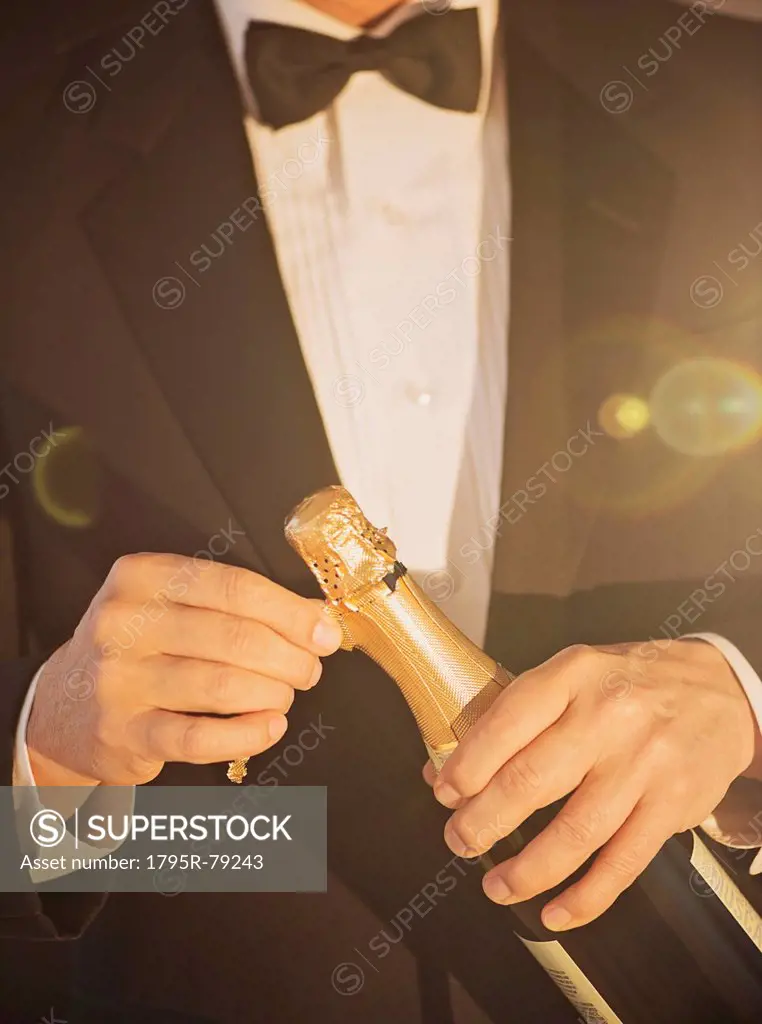 Elegant man opening champagne