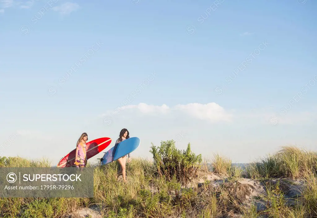 Two female surfers walking on beach