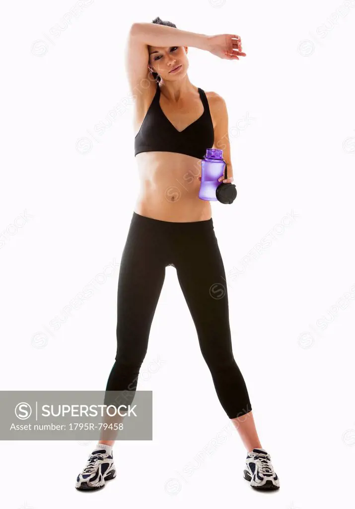 Young woman resting after exercising, studio shot