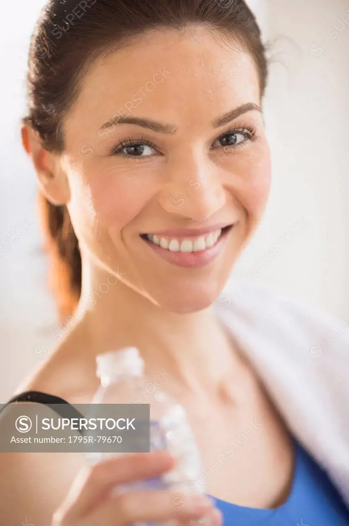 Portrait of woman drinking water in gym