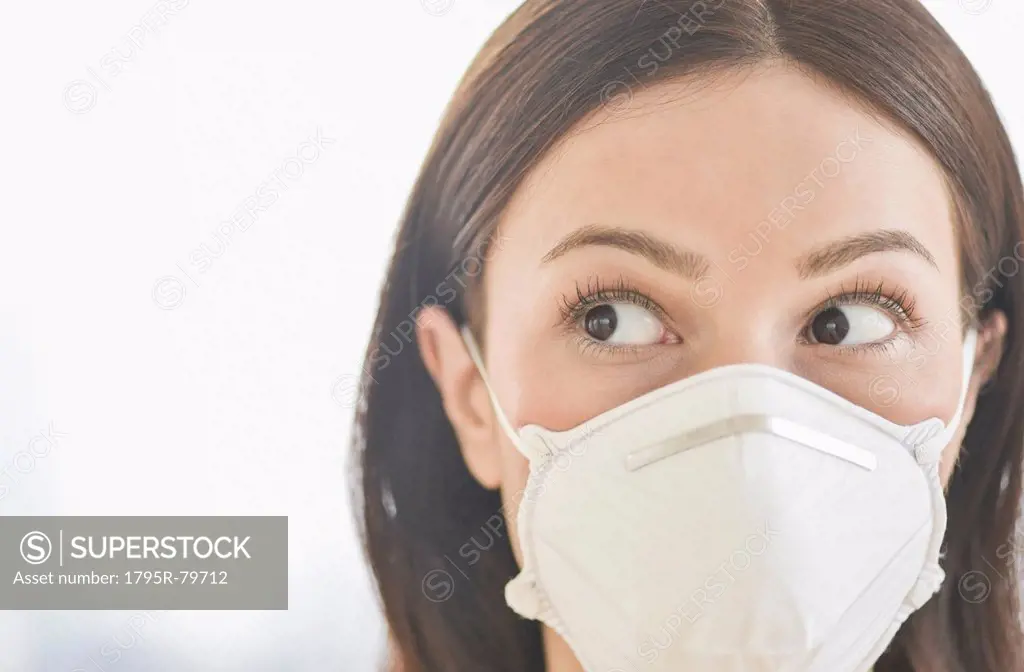 Studio portrait of woman wearing flu mask