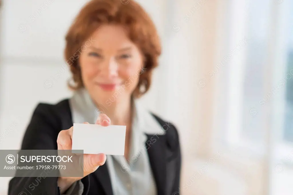 Portrait of businesswoman holding blank business card