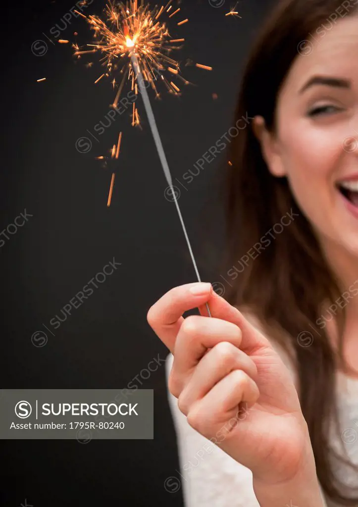 Young woman holding firework