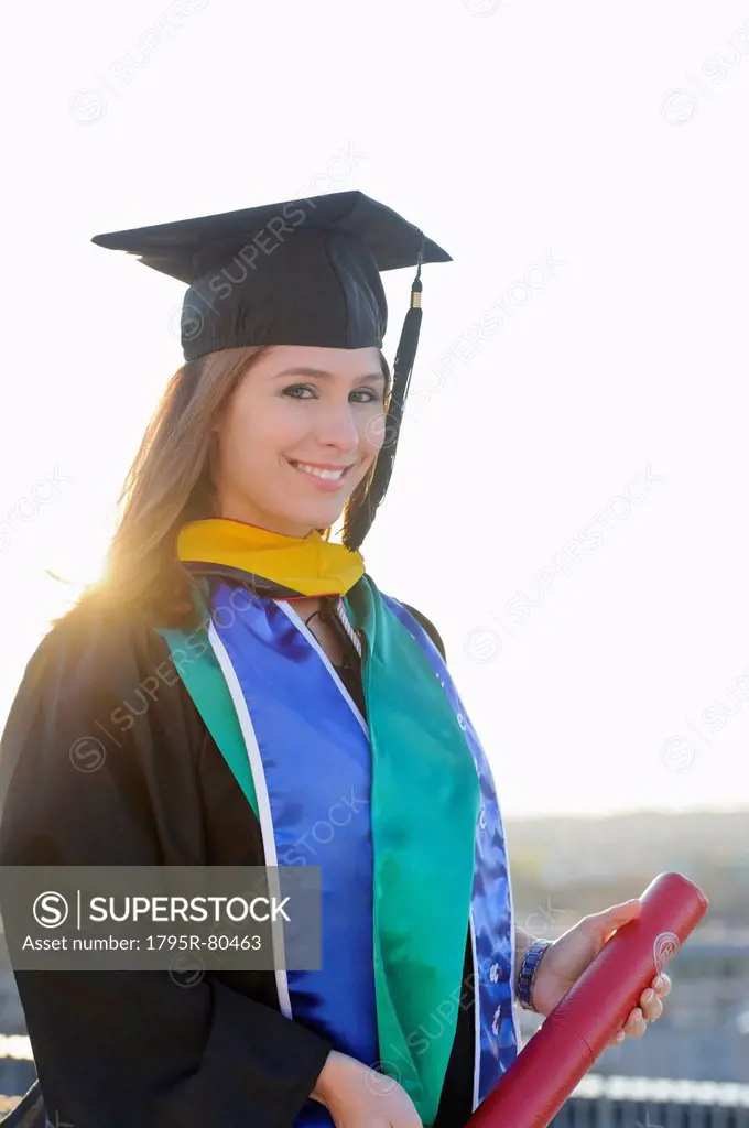 Portrait of graduate student holding diploma