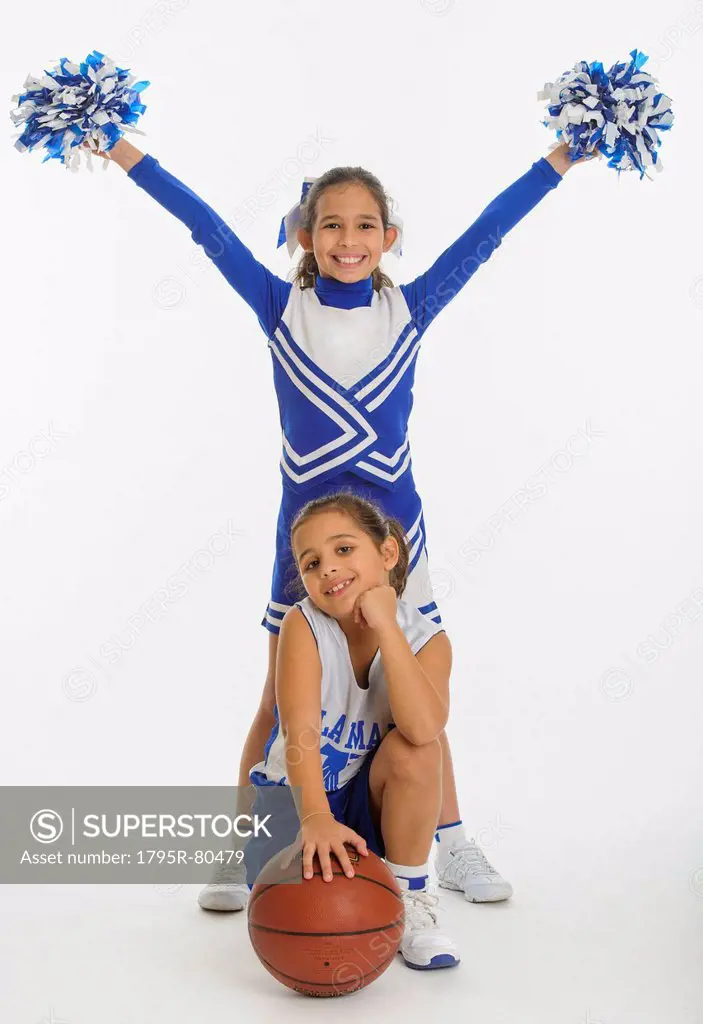 Portrait of cheerleaders 8_9 years  10_11 years holding pom_pom and ball