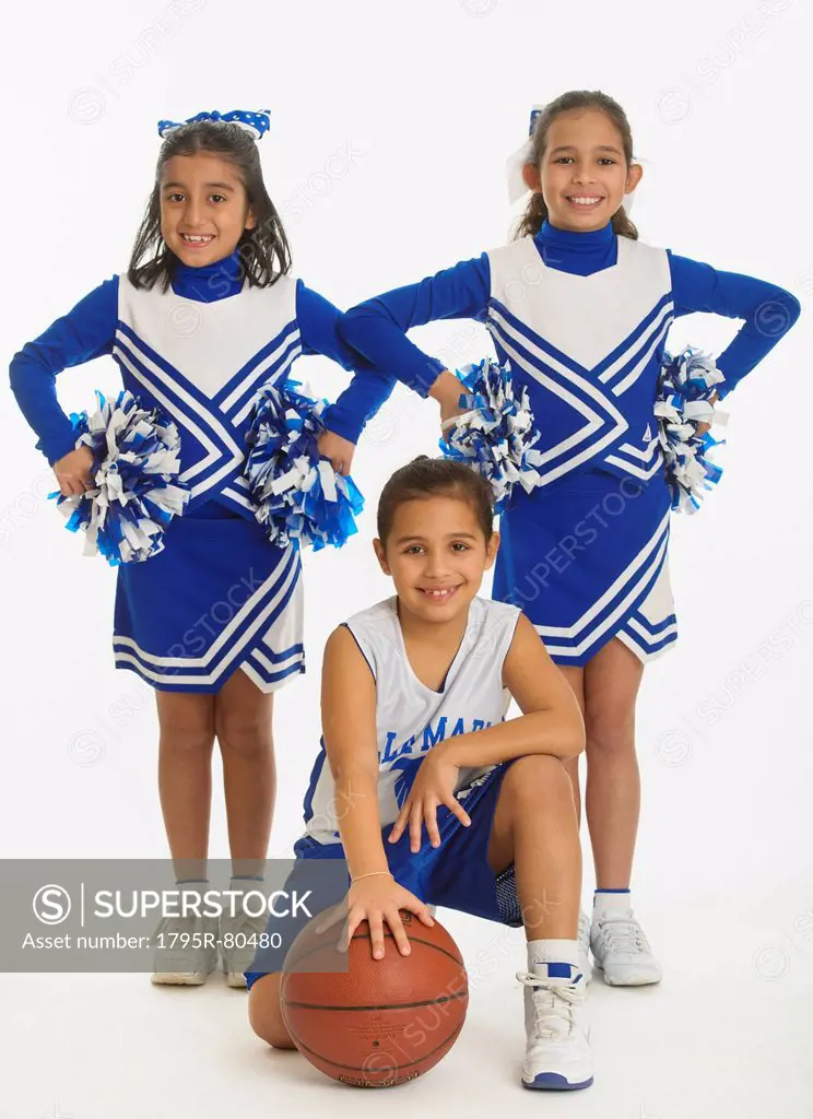 Portrait of cheerleaders 8_9 years  10_11 years holding pom_pom and ball