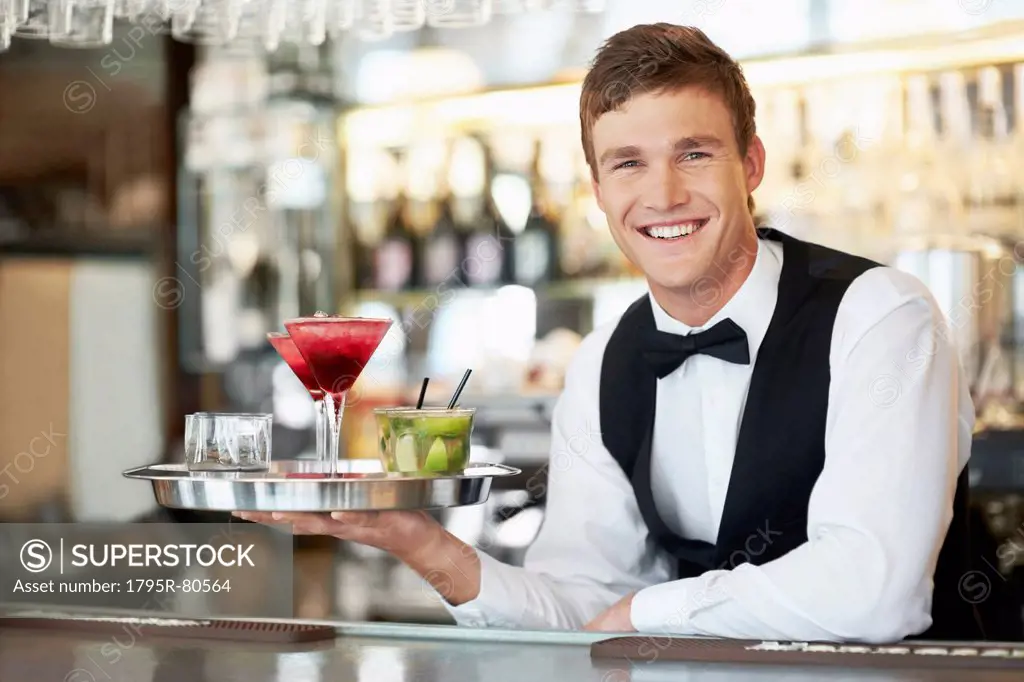 Bartender holding tray with cocktails