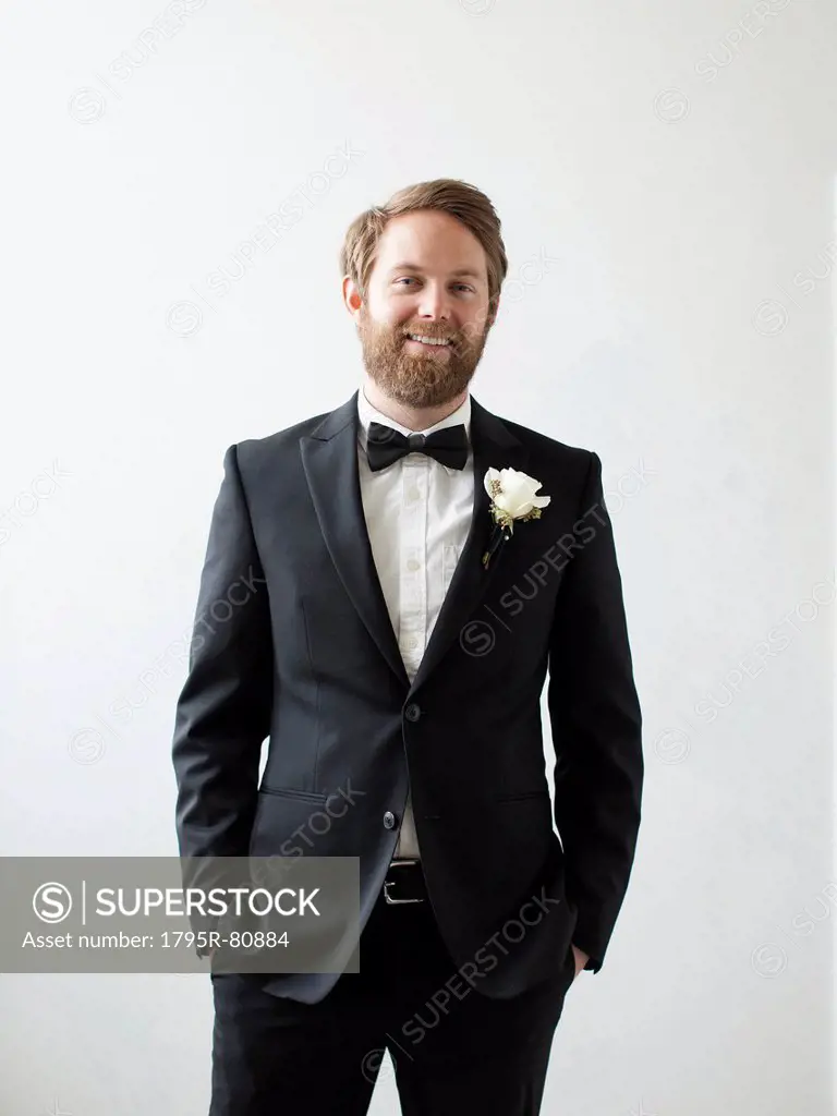 Studio Shot portrait of smiling groom with hands in pockets