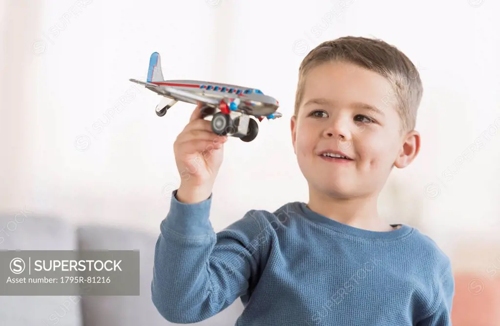 Boy (4-5) playing with toy plane