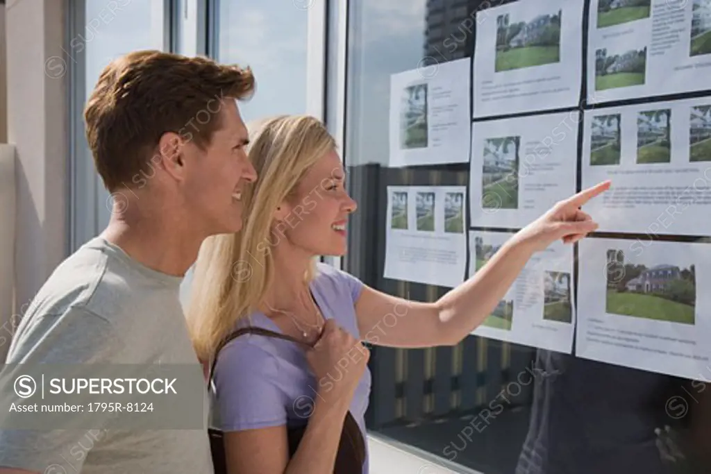 Couple looking at real estate window