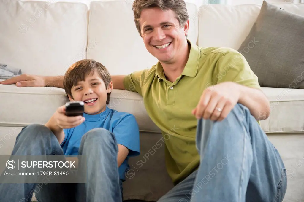 Father and son (8-9) watching television