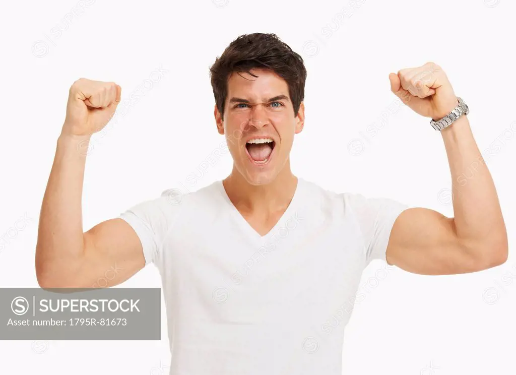 Studio portrait of handsome man cheering and flexing muscles