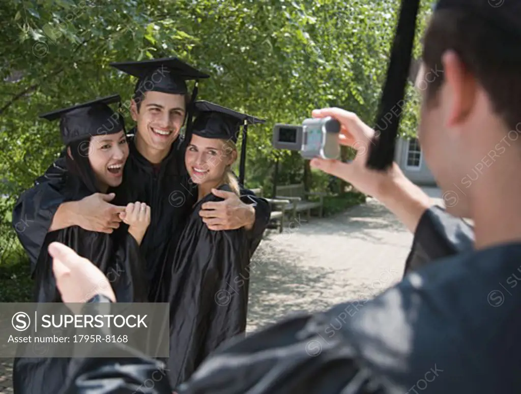 Group of college graduates having photograph taken