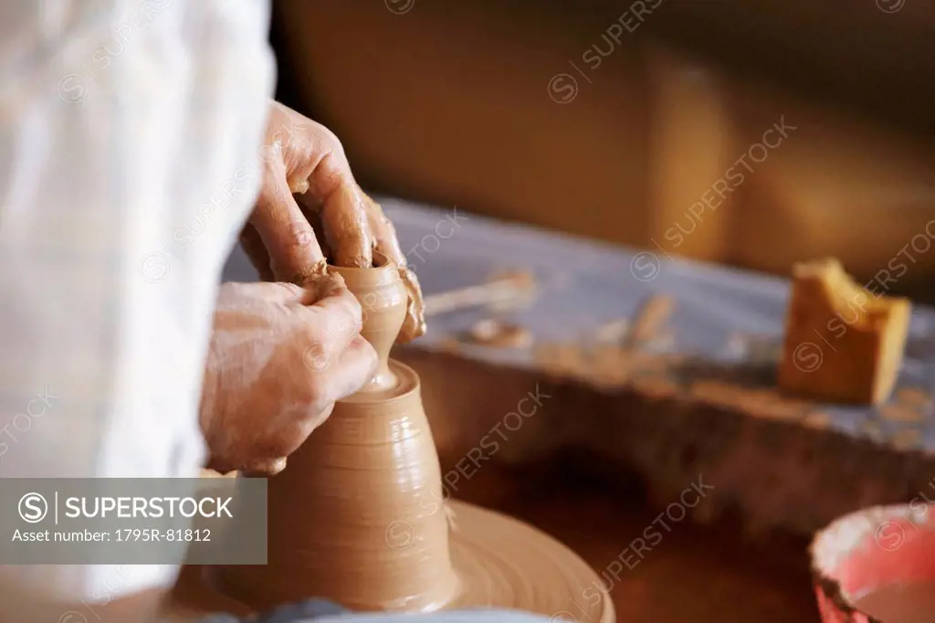 Hands working with clay on potter's wheel