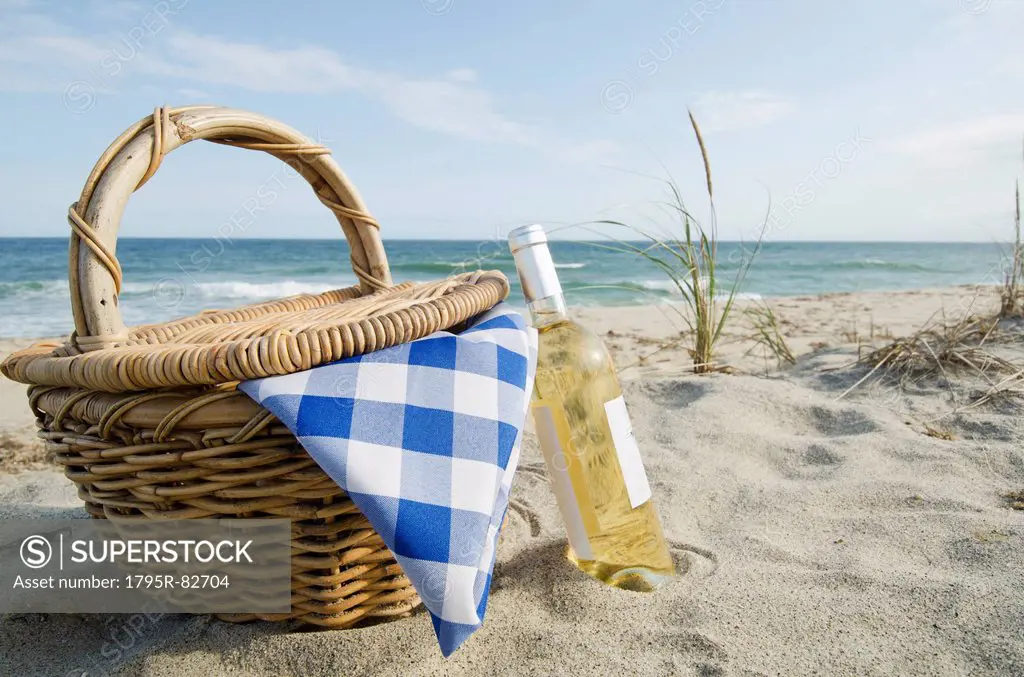 Picnic basket and white wine on beach