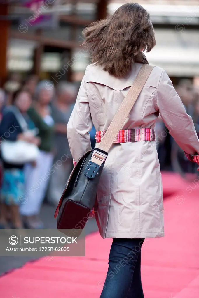 Netherlands, Goirle de Hovel, Young woman walking on city street
