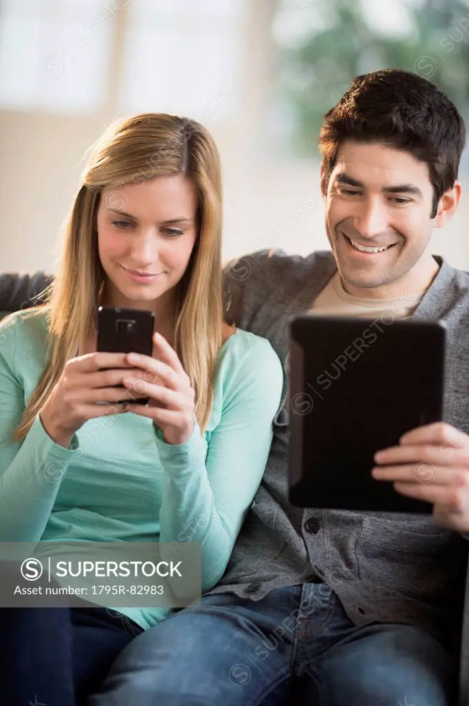 Couple using tablet pc and smartphone