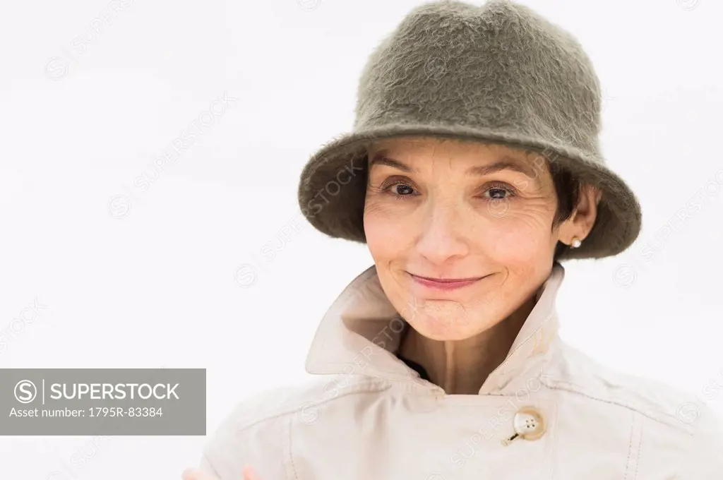 Portrait of smiling woman wearing raincoat and hat