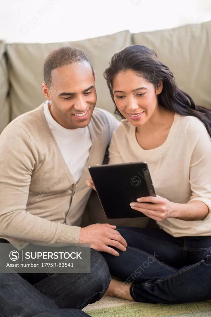 Young couple using digital tablets