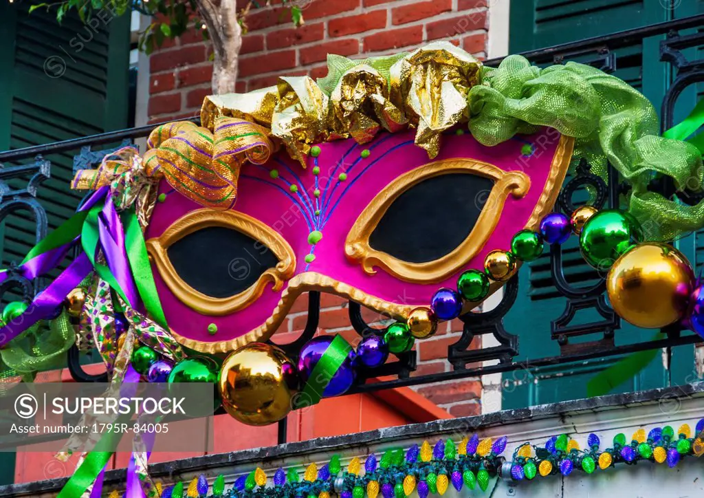 Mardi Gras mask hanging on balcony's railing