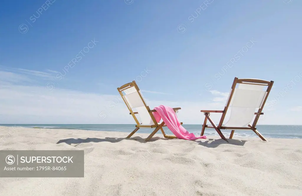 empty lounge chairs on sandy beach