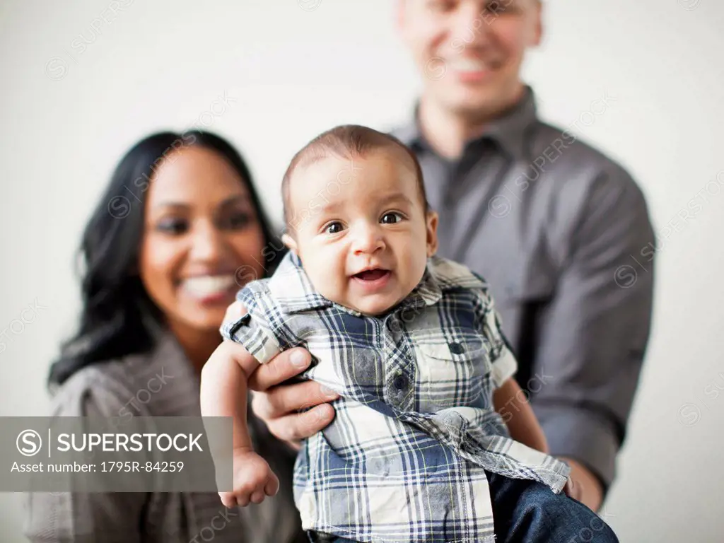 Portrait of happy multiethnic family with baby boy (2-5 months) on front