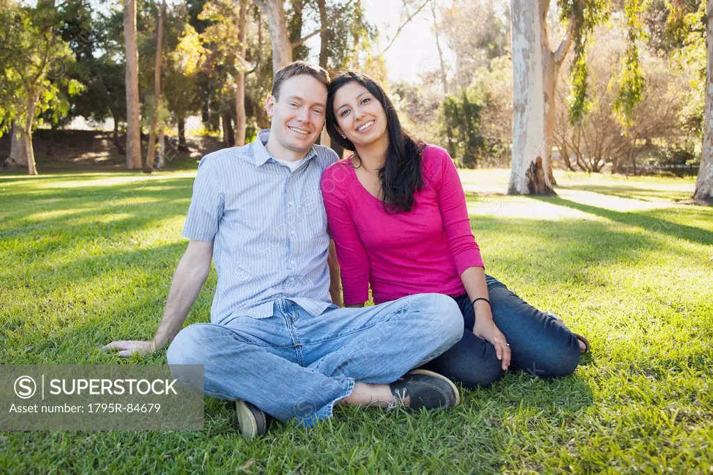 Couple sitting on grass in park