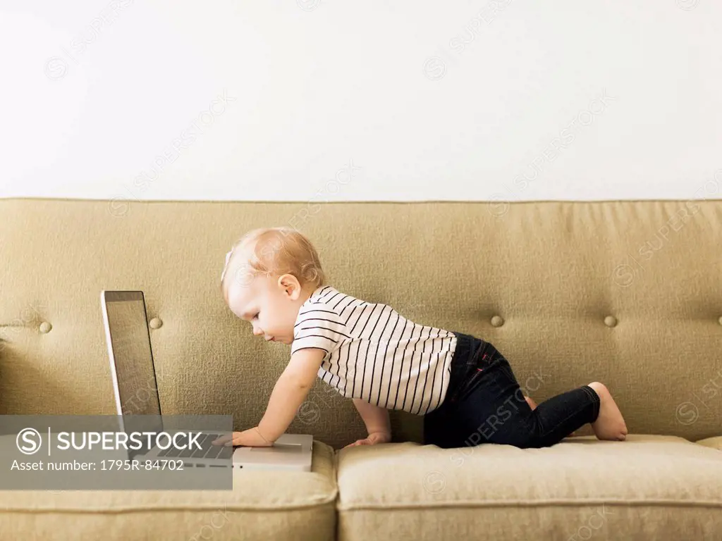 Baby girl (12-17 months) using laptop