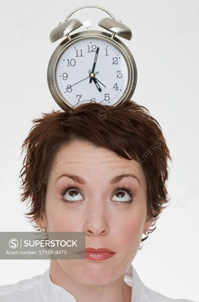 Woman with alarm clock on head
