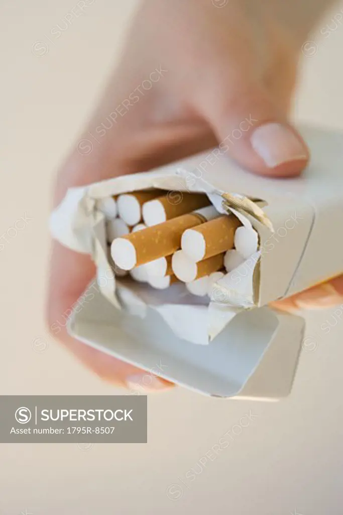 Woman holding open pack of cigarettes
