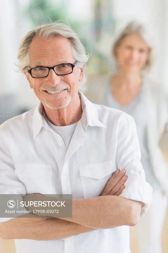 Portrait of senior man, woman in background