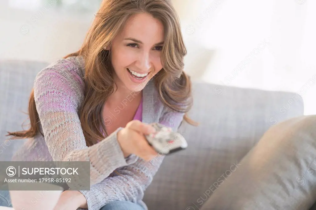 Young woman watching tv on sofa