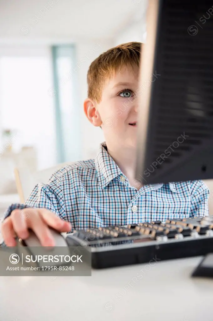 Portrait of boy (4-5) using desktop PC