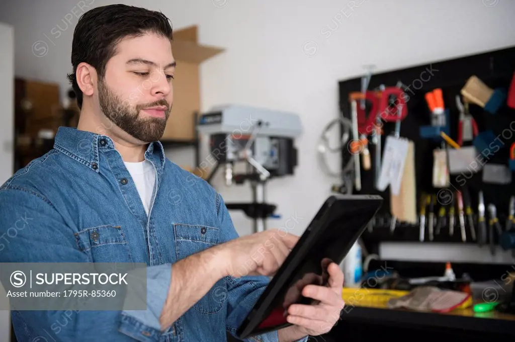 Portrait of man using digital tablet in workshop