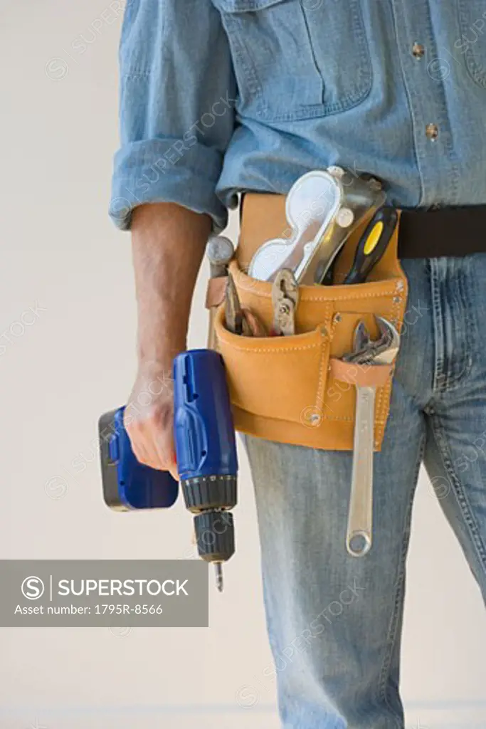Man wearing tool belt and holding drill