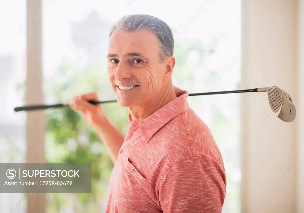 Portrait of man holding golf club on his shoulder