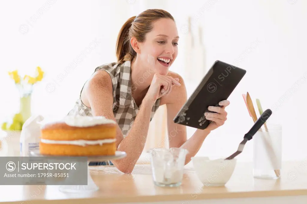 Woman using tablet pc in kitchen