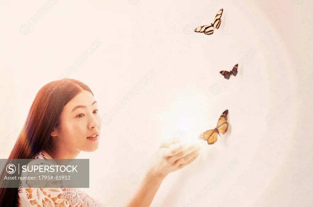 Studio shot of woman looking at butterflies