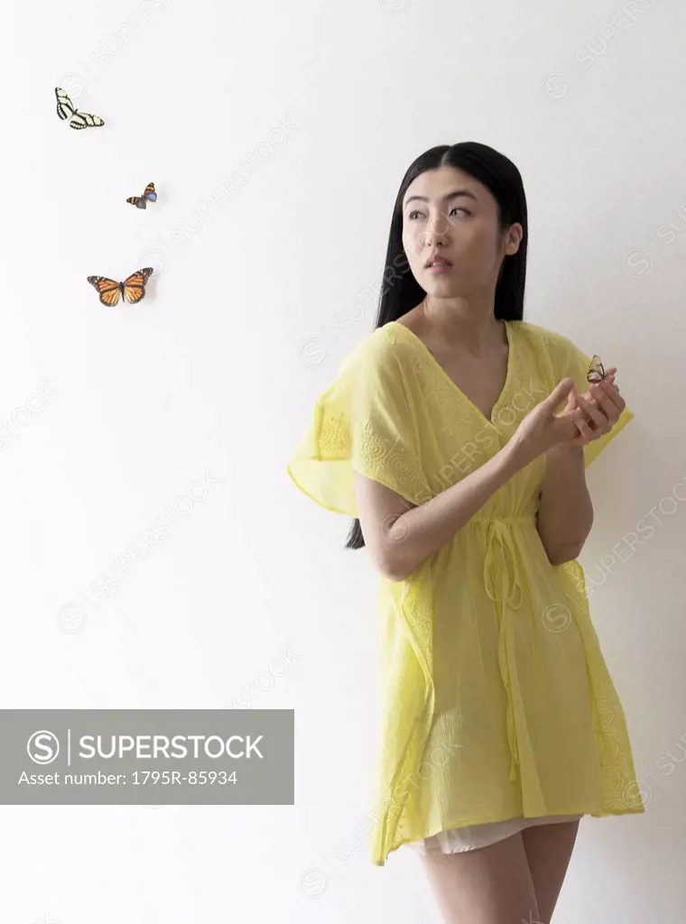 Studio shot of woman looking at butterflies